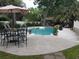 Relaxing backyard pool featuring an umbrella, seating, and lush tropical landscaping at 3646 Hilton Dr, Johns Island, SC 29455