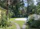 Lush backyard with mature trees, tropical plants, and a glimpse of the inviting pool at 3646 Hilton Dr, Johns Island, SC 29455