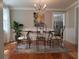 A quaint dining room features hardwood floors, chandelier, colorful rug and artistic peacock painting at 3646 Hilton Dr, Johns Island, SC 29455