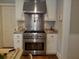 Stainless steel oven and hood with white cabinets and granite countertops with hardwood floors at 3646 Hilton Dr, Johns Island, SC 29455