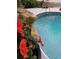Close-up shot of a backyard pool with a rock waterfall and vibrant hibiscus flowers at 3646 Hilton Dr, Johns Island, SC 29455