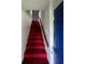 Stairway with bold red carpeting, wooden handrail, and access to upper level at 3646 Hilton Dr, Johns Island, SC 29455