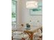 Charming dining area with a glass-top table, white chairs, stylish lighting, and serene beachy artwork at 4856 Green Dolphin Way # Share 6, Kiawah Island, SC 29455