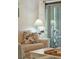 Living room detail showcasing a sofa, side table with lamp, and a view through sliding glass doors at 4856 Green Dolphin Way # Share 6, Kiawah Island, SC 29455