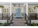 Inviting brick front porch with blue door, columns and stylish plants and outdoor seating at 4940 Lambs Rd, North Charleston, SC 29418
