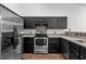 A modern kitchen with stainless steel appliances and dark cabinetry for a stylish look at 5024 Blair Rd, Summerville, SC 29483