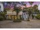 Charming two-story home featuring a welcoming front porch, lush landscaping, and a side staircase to a deck at 504 W Ashley Ave, Folly Beach, SC 29439