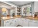 Bright kitchen with white cabinets, stainless steel sink, wood countertop and modern shelves at 504 W Ashley Ave, Folly Beach, SC 29439