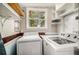 Bright laundry room with washer, dryer, shelving and large window at 504 W Ashley Ave, Folly Beach, SC 29439