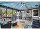 Relaxing screened porch with ceiling fan, comfortable seating and vibrant rug at 504 W Ashley Ave, Folly Beach, SC 29439