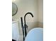 Close-up of a modern bathtub faucet and fixture with a view of the sink and mirror in the background at 5079 Coral Reef Dr, Johns Island, SC 29455