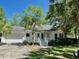 Quaint one-story home featuring a garage and a charming covered front porch and mature landscaping at 5079 Coral Reef Dr, Johns Island, SC 29455