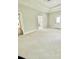 Spacious bedroom featuring a tray ceiling, neutral walls, and views of the ensuite bathroom and closet at 5079 Coral Reef Dr, Johns Island, SC 29455