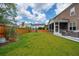 Large, green backyard showcases a wooden fence, grassy lawn, and a screened-in back porch at 525 Yellow Tower Ter, Charleston, SC 29412