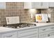 Close-up of gas cooktop, modern backsplash and sleek white countertops at 525 Yellow Tower Ter, Charleston, SC 29412
