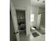 Bathroom with open closet, tub and shower combo, and white tiling at 5681 Captain Kidd Rd, Hollywood, SC 29449