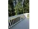 Spacious deck with surrounding mature trees and white railing at 5681 Captain Kidd Rd, Hollywood, SC 29449
