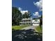 Two-story white farmhouse with a large lawn, gravel driveway and double garages at 5681 Captain Kidd Rd, Hollywood, SC 29449
