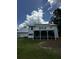 Exterior view of home with metal roof, white siding, screened porch and deck overlooking the lush yard at 5681 Captain Kidd Rd, Hollywood, SC 29449