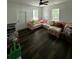 Bright living room with dark wood floors, ceiling fan, and a comfortable pink sofa at 5681 Captain Kidd Rd, Hollywood, SC 29449
