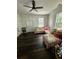 Bright living room with dark wood floors, ceiling fan, and a comfortable pink sofa with many pillows at 5681 Captain Kidd Rd, Hollywood, SC 29449