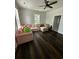 Bright living room featuring dark wood floors, a ceiling fan, and a large pink sofa at 5681 Captain Kidd Rd, Hollywood, SC 29449