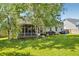 Large, green backyard with a screened porch and mature trees, ideal for Gathering gatherings and outdoor activities at 6159 Fieldstone Cir, Charleston, SC 29414