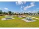 Picnic tables and firepit in a community area with pond views on a sunny day at 715 Hilchot Dr, Summerville, SC 29486