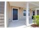 Covered front porch with tan vinyl siding and a black front door with sidelight window at 715 Hilchot Dr, Summerville, SC 29486