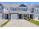 Exterior view of a tan and gray two-story townhome with a front-entry garage and well-kept landscaping at 715 Hilchot Dr, Summerville, SC 29486