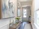Inviting entryway featuring neutral walls, wood floors, modern console table with flowers and art at 754 Blue Iris Way, Summerville, SC 29486