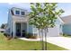 Charming light blue house with a two car garage, black door and well manicured yard at 754 Blue Iris Way, Summerville, SC 29486