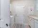 Bright laundry room with modern appliances, white cabinetry, and easy access to the outdoors at 754 Blue Iris Way, Summerville, SC 29486