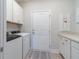 Modern laundry room featuring white appliances, countertop space, and convenient storage cabinets at 754 Blue Iris Way, Summerville, SC 29486