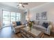 Cozy living area features comfortable seating, a ceiling fan, and large windows for natural light at 754 Blue Iris Way, Summerville, SC 29486