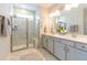 This main bathroom has double sinks, marble floors, a large mirror and glass door shower at 754 Blue Iris Way, Summerville, SC 29486