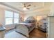 Bright bedroom features a ceiling fan, tray ceiling, wood floors, and a large window with neighborhood views at 754 Blue Iris Way, Summerville, SC 29486