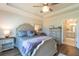 This main bedroom has a decorative ceiling fan, wood floors, and leads to the main bathroom at 754 Blue Iris Way, Summerville, SC 29486