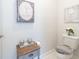 Charming powder room with gray vanity and toilet, decorated with framed artwork and candles at 754 Blue Iris Way, Summerville, SC 29486