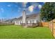 Backyard view showcasing a spacious lawn, privacy fence, and home exterior at 7812 Spring Creek Rd, North Charleston, SC 29418
