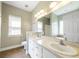 Well-lit bathroom features double sinks, a large mirror, and a window for natural light at 7812 Spring Creek Rd, North Charleston, SC 29418