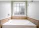 Soaking tub is tiled and features a window for natural light and privacy at 7812 Spring Creek Rd, North Charleston, SC 29418