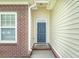 Close-up of the home's entrance, showcasing a stylish front door and brick accents at 7812 Spring Creek Rd, North Charleston, SC 29418