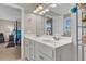 Bright bathroom featuring a double vanity with solid surface countertops and a view into the bedroom at 9009 Cat Tail Pond Rd, Summerville, SC 29485
