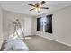 Bedroom with tan carpet, ceiling fan, and a window with dark curtains, undergoing renovation at 9009 Cat Tail Pond Rd, Summerville, SC 29485