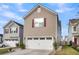 View of a two-story home with a white two-car garage and beautifully maintained landscaping at 9009 Cat Tail Pond Rd, Summerville, SC 29485