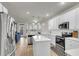 Bright kitchen features white cabinets, stainless steel appliances, island with quartz countertop and designer pendant lighting at 9009 Cat Tail Pond Rd, Summerville, SC 29485