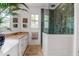 Bright bathroom with white cabinetry, tan countertops, and walk-in tiled shower at 932 Middle St, Sullivans Island, SC 29482