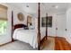 Bright bedroom featuring a four-poster bed, hardwood floors, and natural light from multiple windows at 932 Middle St, Sullivans Island, SC 29482