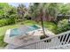 A backyard pool with patio, lounge chairs, umbrella, palm tree, and lush landscaping at 932 Middle St, Sullivans Island, SC 29482